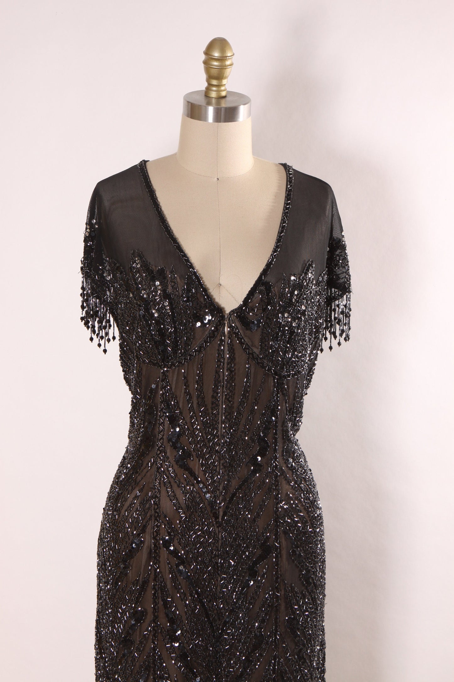 Late 1980s Early 1990s Black Sequin and Beaded Fringe Short Sleeve Flapper Style Sheer Nude Illusion Dress by Peak Evenings -M