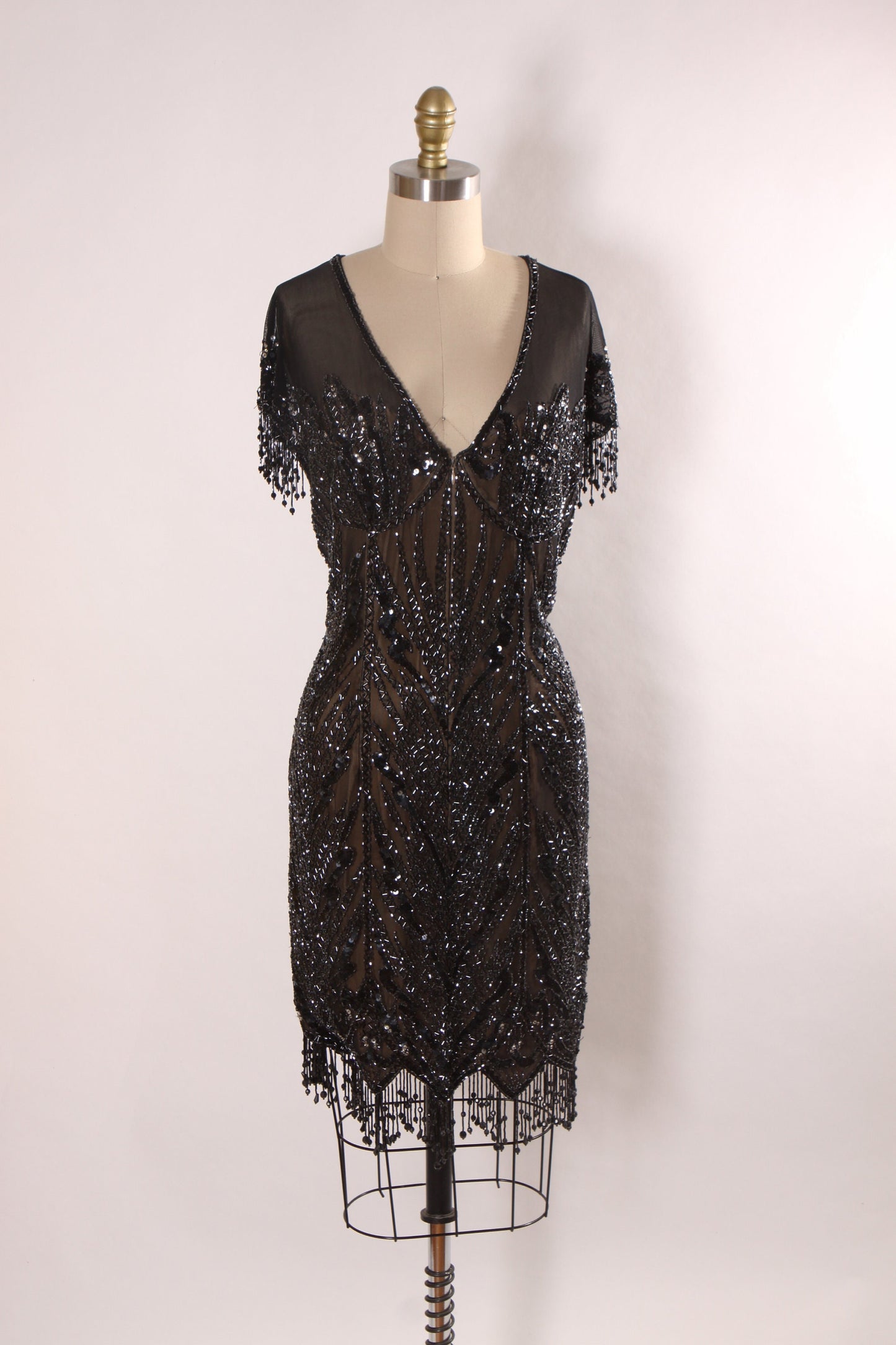 Late 1980s Early 1990s Black Sequin and Beaded Fringe Short Sleeve Flapper Style Sheer Nude Illusion Dress by Peak Evenings -M